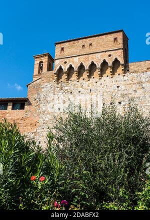 Fragment du mur de la forteresse avec une tour défensive et un clocher à San Gimignano, en Italie Banque D'Images