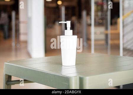 Une bouteille de gel hydroalcoolique à l'entrée d'un magasin pendant la pandémie du coronavirus. Banque D'Images