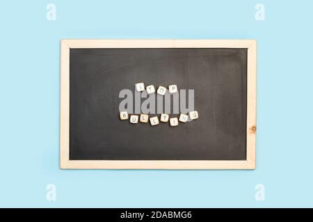 Arrêter l'intimidation mot fait avec des cubes de lettre en bois sur un tableau noir sur fond bleu clair Banque D'Images