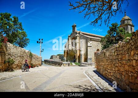 Pèlerin sur un vélo à côté de l'église de Nuestra Señora del Manzano, notre Dame de Manzano, ou Iglesia de Santa María del Manzano. French Way, Way of Banque D'Images