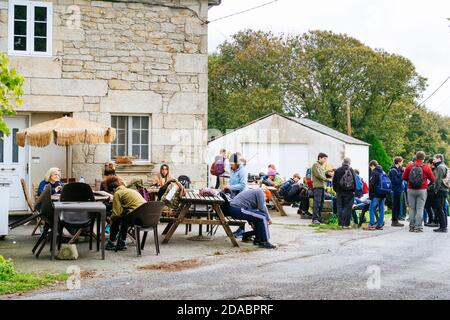 Les pèlerins se reposent et mangent sur la terrasse de l'auberge-restaurant Casa Cruceiro de Ferreiros. French Way, Way of St. James. Ferreiros, Concello de Paradela, lu Banque D'Images