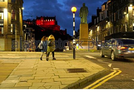 Édimbourg, Écosse, Royaume-Uni. 11 novembre 2020. Le château d'Edimbourg est toujours illuminé dans le rouge du pavot souvenir contre le ciel bleu au crépuscule. Rues calmes grâce aux mesures de verrouillage Tier 3 Covid-19. Vue depuis North Castle Street. Crédit : Craig Brown/Alay Live News Banque D'Images