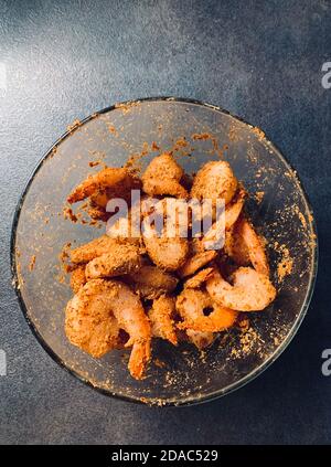 Bol transparent avec crevettes marinées et pâte de gingembre à l'ail, poivre au piment et sel, épices et herbes, pour faire des oiseaux de fruits de mer indiens Banque D'Images