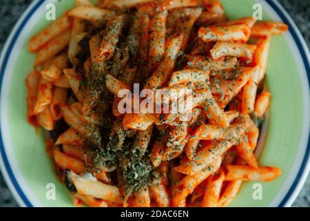 Macaroni blanc à la tomate, au Chili, à l'origan, au fromage et aux épices Banque D'Images