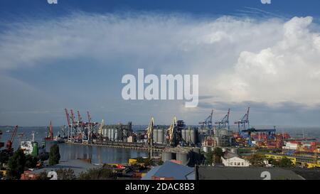 Port portuaire avec terminal d'élévateur de grain et zone de conteneurs. Vue industrielle sur la mer sous les nuages orageux dans un ciel élevé. Port maritime paysage dans le port de Banque D'Images