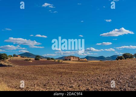 Vue panoramique sur le paysage avec champs, ciel bleu, beaux nuages, ancienne ferme abandonnée, la Mancha, Espagne Banque D'Images