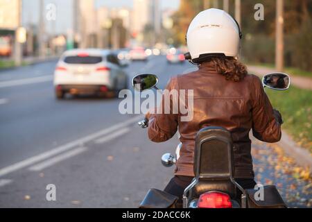 Biker Girl fait une moto dans la ville. Vue de la première personne sur les routes urbaines Banque D'Images