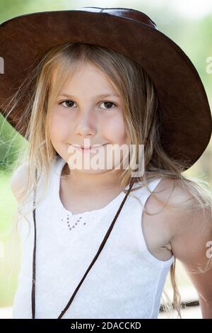 Portrait de jeune fille gaie en chapeau de cuir de cow-boy, blonde mignon enfant avec le sourire Banque D'Images