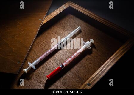 Vaccin contre le virus Corona, vaccin Covid-19 dans la boîte. Fond blanc et seringues. Banque D'Images