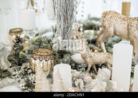 Table en verre festive du nouvel an. Carte de vœux. Il y a des verres à vin et des couverts dans les branches de l'arbre de Noël. Décoration dorée Banque D'Images