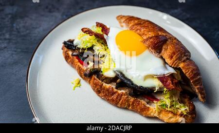 Sandwich-déjeuner Portobello croissant avec œuf ensoleillé Banque D'Images