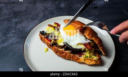 Sandwich-déjeuner Portobello croissant avec œuf ensoleillé Banque D'Images