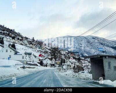 Route à neige traversant la ville d'Hermansverk à Leikanger, Sogndal, Norvège. Paysage d'hiver. Banque D'Images