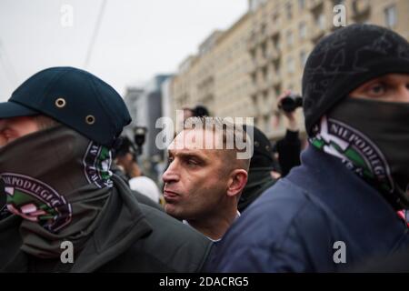 Robert Bakiewicz, président de l’Association pour la marche de l’indépendance, qui s’occupe avec ses gardes du corps durant le jour de l’indépendance.des milliers de personnes ont participé à une marche d’extrême-droite annuelle à Varsovie pour marquer le jour de l’indépendance de la Pologne, défiant ainsi les restrictions imposées aux coronavirus. Un appartement à côté du pont de Poniatowski aurait été incendié pour avoir été décoré de drapeaux arc-en-ciel et de banderoles “Women’s Strike”. Cette année, la marche du jour de l'indépendance a été planifiée dans une formule motorisée. Banque D'Images