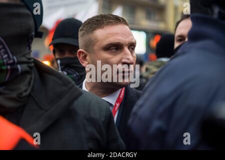 Robert Bakiewicz, président de l’Association pour la marche de l’indépendance, qui s’occupe avec ses gardes du corps durant le jour de l’indépendance.des milliers de personnes ont participé à une marche d’extrême-droite annuelle à Varsovie pour marquer le jour de l’indépendance de la Pologne, défiant ainsi les restrictions imposées aux coronavirus. Un appartement à côté du pont de Poniatowski aurait été incendié pour avoir été décoré de drapeaux arc-en-ciel et de banderoles “Women’s Strike”. Cette année, la marche du jour de l'indépendance a été planifiée dans une formule motorisée. Banque D'Images