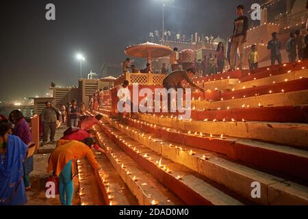Varanasi, Inde, novembre 2015. Des gens éclairant des bougies dans un ghat sur le fleuve Ganges la nuit. Banque D'Images
