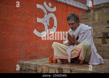 Varanasi, Inde, novembre 2015. Un homme prie dans un ghat sur le fleuve Ganges. Banque D'Images