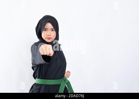 femme dans hijab dans le pencak silat uniforme pose frapper vers l'avant avec espace de copie en arrière-plan isolé Banque D'Images