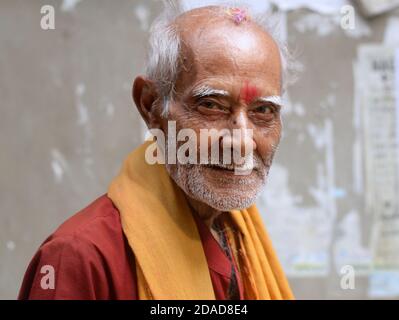 Ancien prêtre indien du temple hindou / pèlerin avec la marque rouge tilak sur son front élevé pose pour la caméra pendant le festival religieux Navratri. Banque D'Images