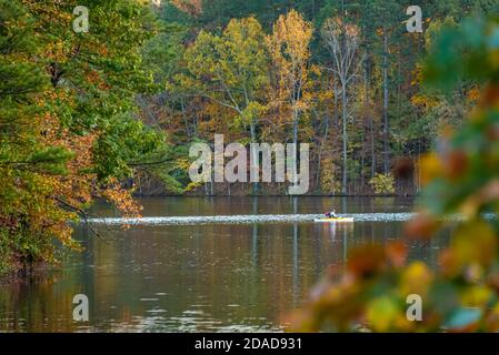 Kayakiste avec son chien appréciant une belle soirée d'automne au coucher du soleil sur le lac de Stone Mountain dans le parc de Stone Mountain près d'Atlanta, Géorgie. (ÉTATS-UNIS) Banque D'Images