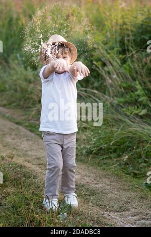 Joyeux garçon attrapant des bulles de savon dans la nature en été Banque D'Images