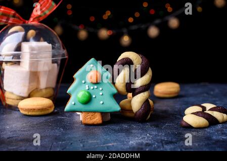 Pain d'épice sous la forme d'un petit arbre de Noël vert, biscuits sablés sous la forme de bonbons. Les lumières et le contenu du nouvel an. Joyeux noël Banque D'Images