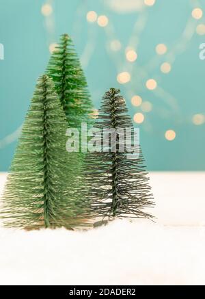 Arbres de Noël miniatures sur une table en bois avec de la neige. Scène réaliste imitation. Bannière. Banque D'Images