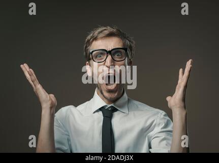 Un homme stressé en colère criant à haute voix, il est frustré et nerveux Banque D'Images