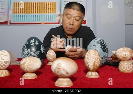 Zhangjiakou, Zhangjiakou, Chine. 12 novembre 2020. Hebei, CHINA-Qiao Changgui, 57 ans, un ouvrier ordinaire, s'intéresse à la sculpture et à la peinture depuis son enfance. Il a commencé à essayer la sculpture d'oeufs il y a 20 ans et ses compétences ont progressivement mûri.Ã‚Â Qiao Changgui oeuf décorant des travaux avec des oeufs, l'oeuf d'autruche comme matière première, après choisir des oeufs, la perforation, fluide clair, tels que le dessin, la sculpture, le processus de polissage est terminé, le sujet couvre la culture régionale, culture traditionnelle et autres sujets, faire de petits oeufs de coquille ''gravé'' œuvres montrent le 'stage' de la culture. (Image de crédit : Banque D'Images