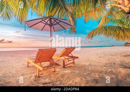 Plage tranquille. Paysage exotique de plage tropicale. Magnifique coucher de soleil tropical, deux chaises longues, parasols. Station balnéaire inspirante Banque D'Images