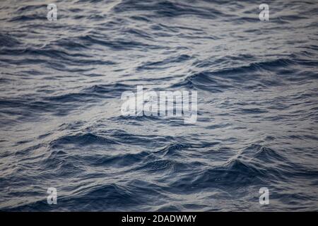 Bleu de la mer avec des vagues de lumière. Texture de fond d'un océan bleu profond calme avec des ondulations sur la surface de l'eau de mer Banque D'Images