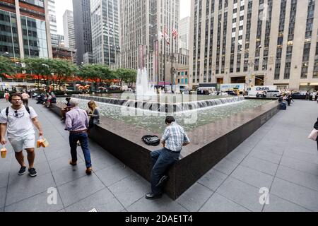 NEW YORK, États-Unis - 18 septembre 2017 : scène de rue de Manhattan. Américains dans les rues de New York. Un homme est assis près d'une fontaine sur la 6e Avenue de Manhattan Banque D'Images
