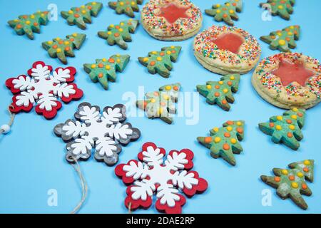 Un motif de biscuits maison de Noël et de flocons de neige décoratifs disposés en rangées sur un fond bleu. Orientation horizontale. Banque D'Images