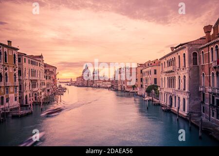 Paysage de voyage d'été incroyable. Coucher de soleil sur le Grand Canal et la basilique Santa Maria della Salute à Venise, Italie. Couleurs relaxantes Banque D'Images