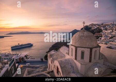 Vue fantastique en soirée sur l'île de Santorini. Pittoresque coucher de soleil de printemps sur la célèbre vue station Fira, Grèce, Europe. Présentation du concept de déplacement. Coucher de soleil Banque D'Images