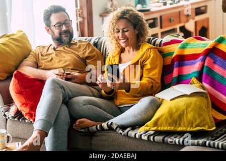 Visioconférence et connexion avec des amis modernes concept en ligne pour un couple magnifique et joyeux adulte à la maison utilisant la technologie internet assis sur le canapé - les gens ensemble et la vie de communication Banque D'Images