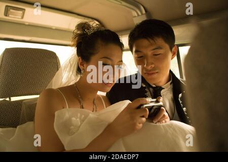 BEIJING, CHINE - JUIN 2006: Li Xiao Ang, 26 ans, consultant d'entreprise et sa mariée-à-être LI Yue, 27 ans, qui travaille dans une agence de publicité regarder à travers le Banque D'Images