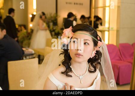 BEIJING, CHINE - JUIN 2006: Une jeune mariée-à-être attend un studio libre après avoir terminé son quatrième costume et changement de coiffure ce matin à Vivi Banque D'Images