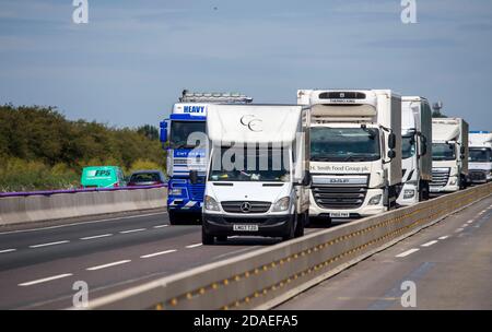 Camions voyageant le long des travaux routiers sur l'autoroute M1 dans les Midlands, en Angleterre. Banque D'Images