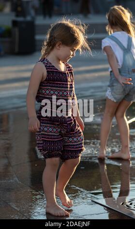 KIEV, UKRAINE - 05 juin 2018: Gaie et heureuse fille jouant dans une fontaine d'eau et appréciant les ruisseaux frais de l'eau dans une journée chaude. Été chaud. Banque D'Images