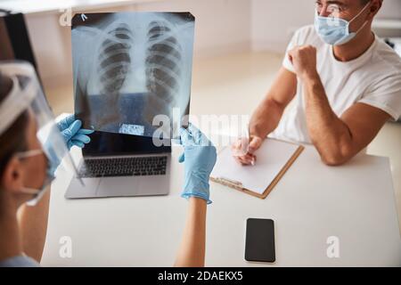 Contrôle médical responsable de l'image radiologique tout en tendant vers le patient Banque D'Images