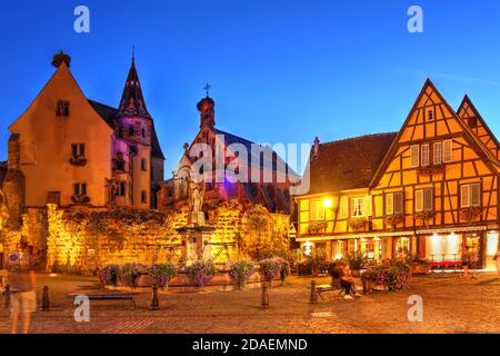 Scène nocturne sur la place Staint Leon, Eguisheim, village médiéval merveilleusement préservé de la région viticole d'Alsace, avec le Château Saint S. Banque D'Images