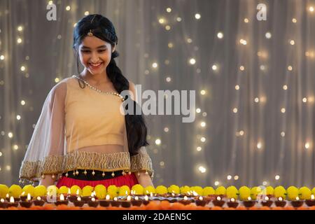 Belle jeune fille regardant et souriant aux décorations de Diwali Banque D'Images