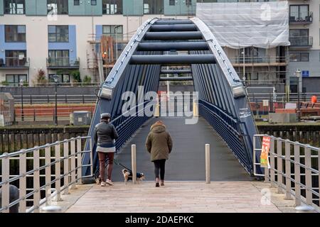 Port de plaisance de Swansea, Swansea, Royaume-Uni. 12 novembre 2020. Les gens traversent aujourd'hui la passerelle reliant les stations d'accueil de Swansea à la marina de Swansea lors d'une pause dans le temps humide et venteux qui traverse le Royaume-Uni. Credit: Phil Rees/Alamy Live News Banque D'Images