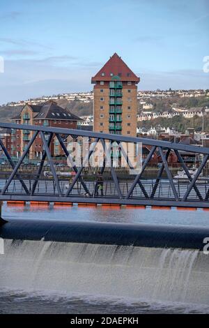 Port de plaisance de Swansea, Swansea, Royaume-Uni. 12 novembre 2020. Les gens traversent aujourd'hui la passerelle reliant les stations d'accueil de Swansea à la marina de Swansea lors d'une pause dans le temps humide et venteux qui traverse le Royaume-Uni. Credit: Phil Rees/Alamy Live News Banque D'Images