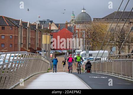 Port de plaisance de Swansea, Swansea, Royaume-Uni. 12 novembre 2020. Les gens traversent aujourd'hui la passerelle moderne qui relie les quais de Swansea à la marina de Swansea lors d'une pause dans le temps humide et venteux qui traverse le Royaume-Uni. Credit: Phil Rees/Alamy Live News Banque D'Images