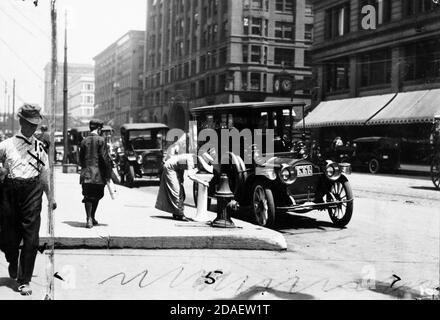 Vue sur la femme qui boit depuis la fontaine d'eau de State Street, Chicago, Illinois, vers 1915. Banque D'Images