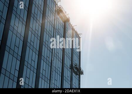 Construction suspendue à cheval près du mur du bâtiment résidentiel de highttower avec façade moderne en métal de verre. Ingénierie ville urbaine Banque D'Images