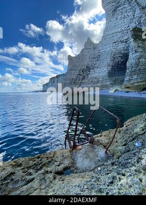 Échelle descendant dans la mer avec sur l'arrière-plan des falaises de calcaire à Etretat, côte française Banque D'Images