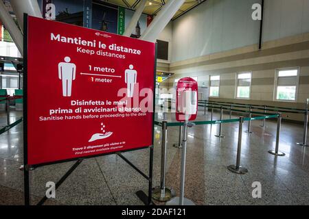 Le panneau à l'aéroport d'Olbia en Sardaigne, Italie, rappelle aux passagers de garder la distance sociale et de désinfecter les mains pendant la crise du coronavirus en Italie. Banque D'Images